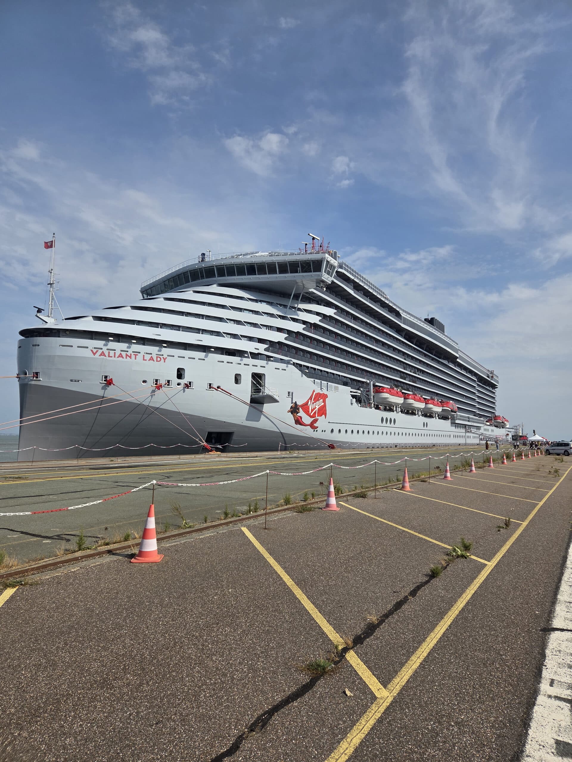 Paquebot Valiant Lady de Virgin Voyages amarré au quai par temps clair.